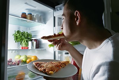 Young man eating at night